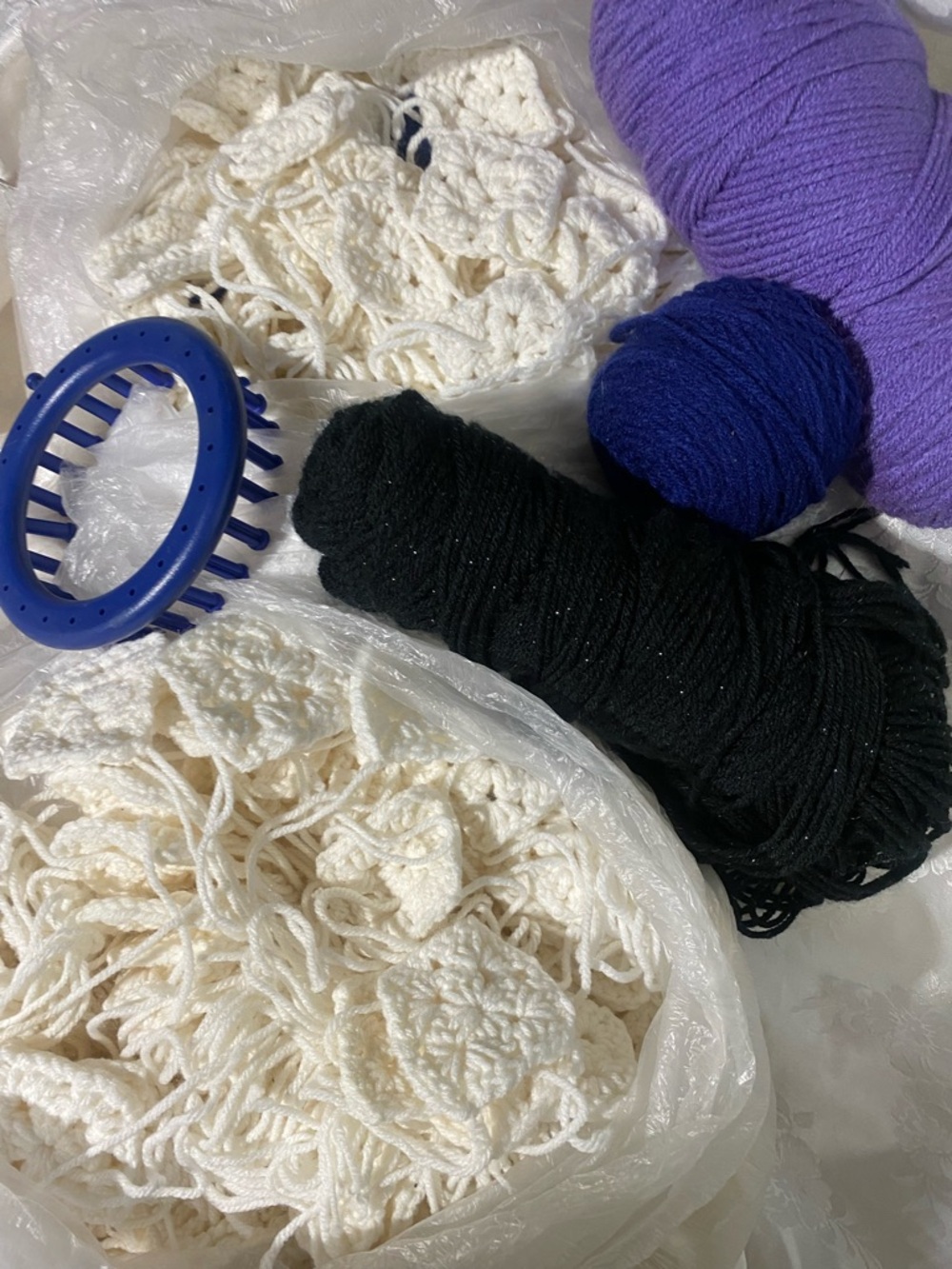 Crochet craft lot including handmade granny squares and yarn.